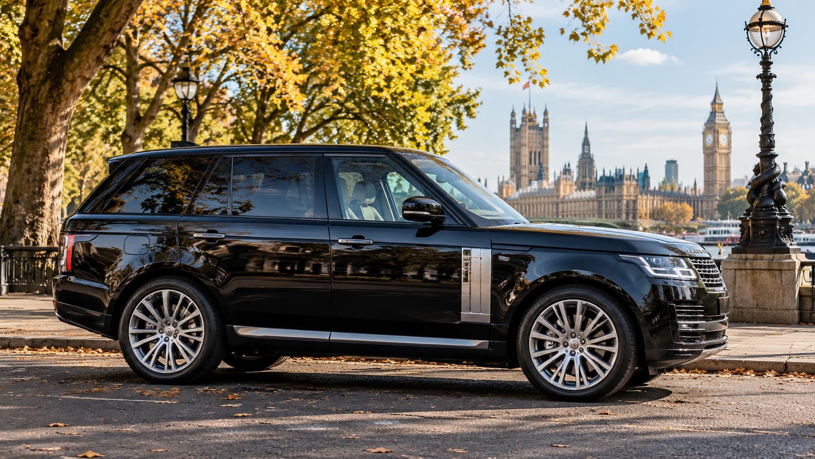 A black Range Rover parked on a tree-lined riverside road in autumn, the Palace of Westminster and the Elizabeth Tower across the water
